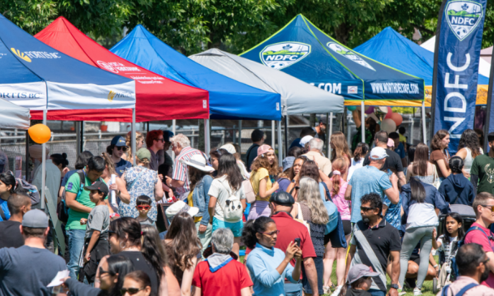 A crowd gathers at booths around the North Delta Market.