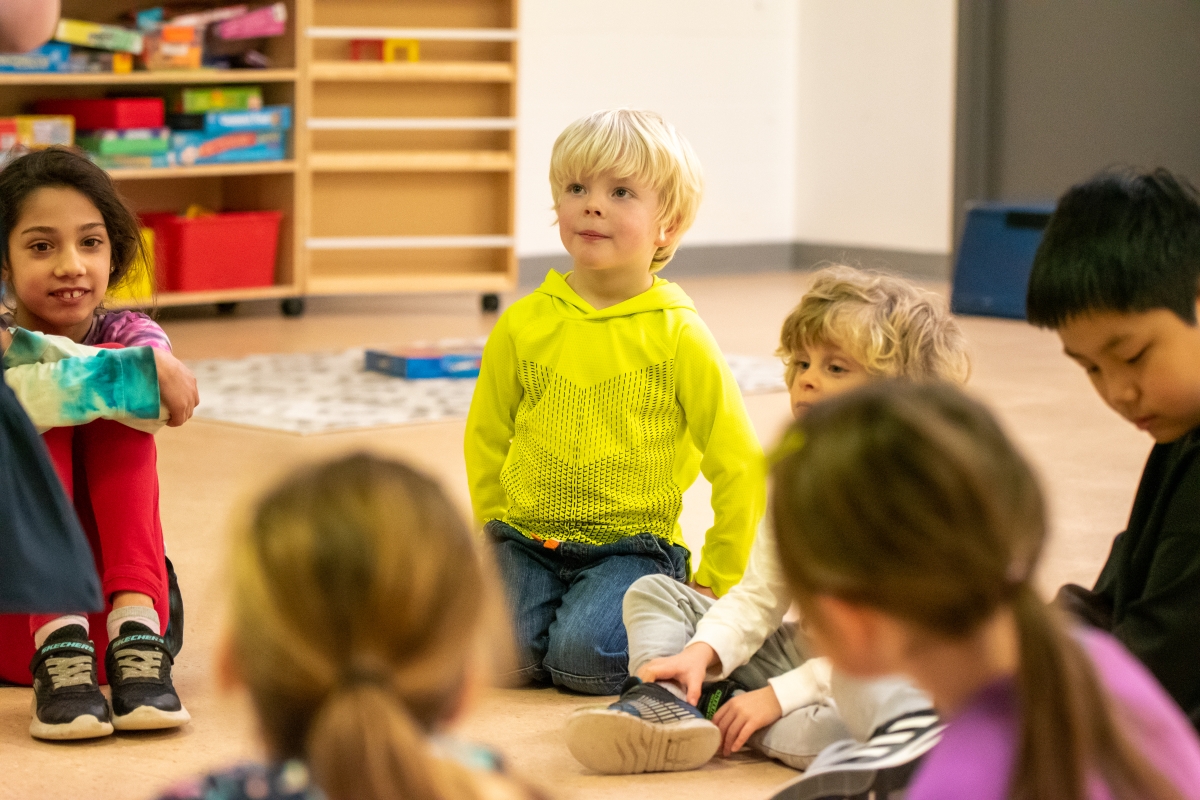 A camper listens to the day camp leader attentively.
